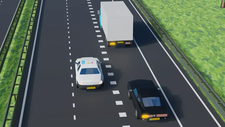 De lesauto is een rijstrook naar links opgeschoven, zodat de zwarte auto en de vrachtwagen op de invoegstrook ruimte hebben om in te voegen