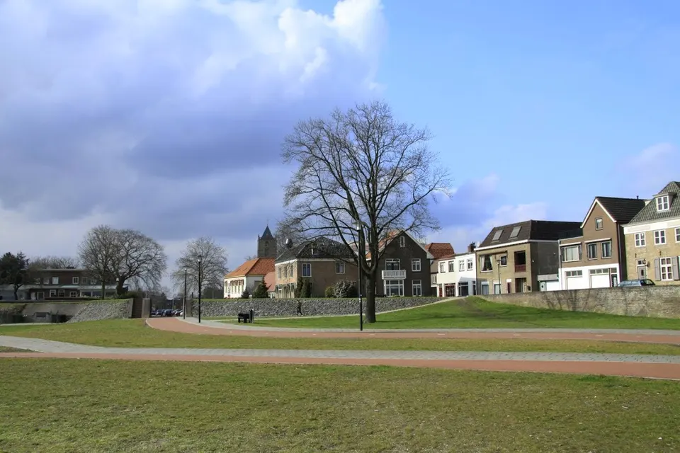 Grasveld bij woningen — omgeving van Tiel