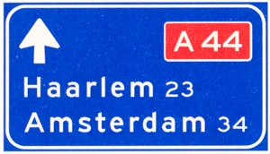 Lage beslissingwegwijzer langs autosnelweg voor de doorgaande richting, met interlokale doelen en routenummer autosnelweg