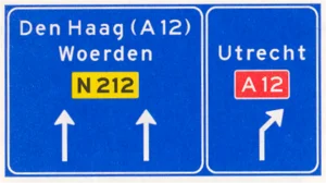 Voorsorteren op niet-autosnelweg. Bord met interlokale doelen, routenummers en verwijzing naar autosnelweg